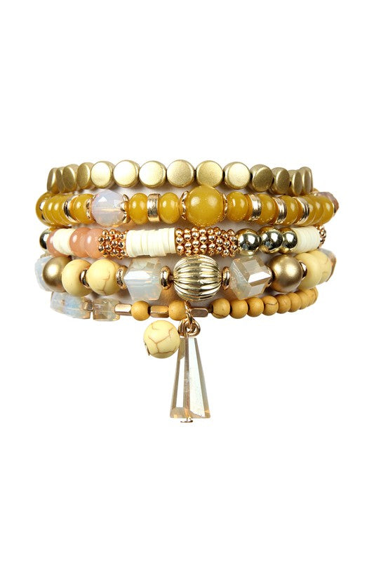 This is a photo of ta Multi Beads Stretch bracelet in mustard which features metal, acrylic and natural stone beads in mustard, gold and white.  