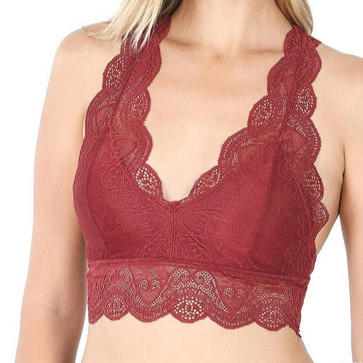 This is a photo of a model wearing a Strech Lace Bralette in brick red. The bra has a traditional spaghetti strap, v shaped neckline and features extra wide lace camisole straps and bottom lace band.